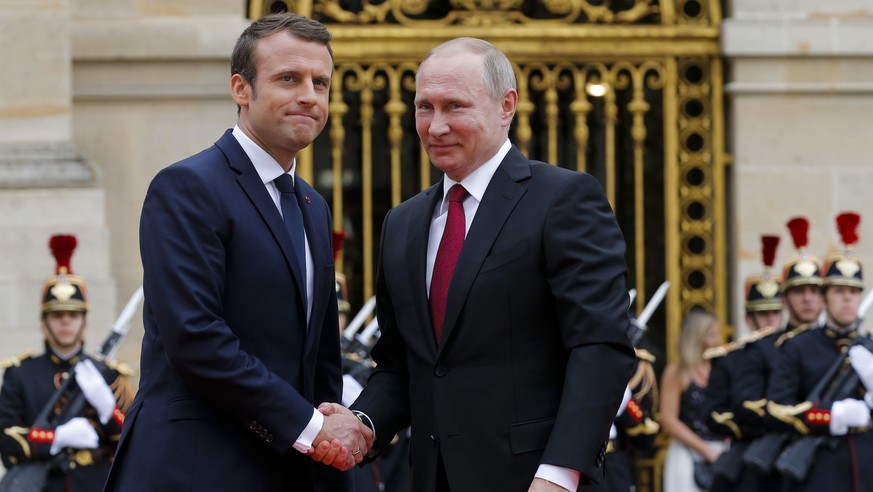 Russian President Vladimir Putin, right, is welcomed by French President Emmanuel Macron at the Palace of Versailles, near Paris, France, Monday, May 29, 2017. Monday's meeting comes in the wake of th ...