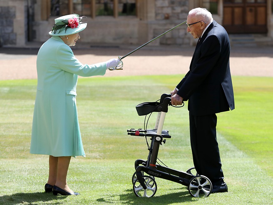 Königin Elizabeth II. schlägt Tom Moore, Weltkriegsveteran und Rekord-Spendensammler, während einer Zeremonie im Freien auf Schloss Windsor zum Ritter.