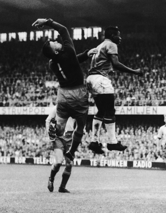 Sweden&#039;s Goalkeeper Kalle Svensson (left No. 1) and Brazil&#039;s inside-left Pele (Edison Arantes do Nascimento) strike a ballet- like pose as they leap for the ball in the World Cup football fi ...