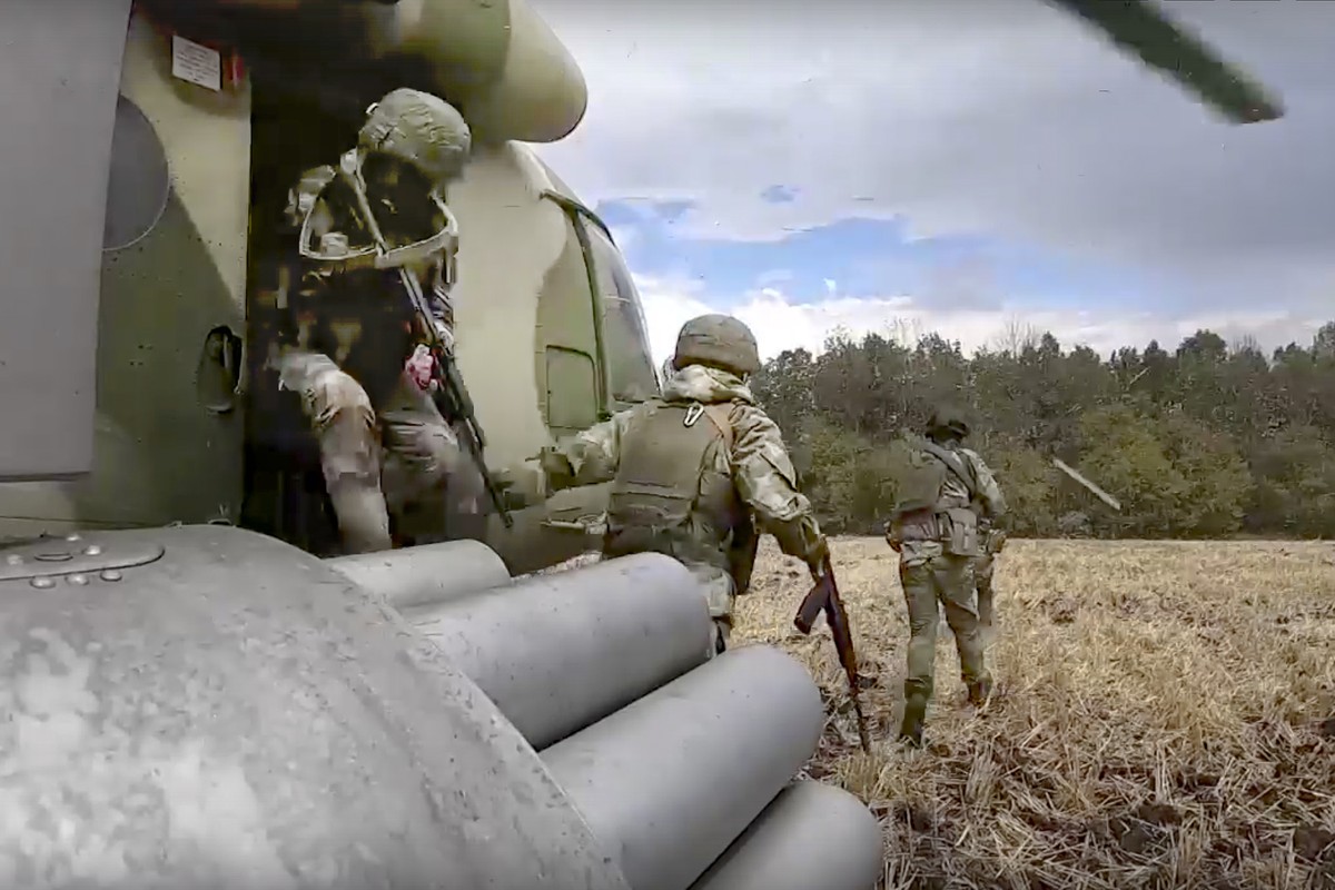 FILE - In this handout photo taken from video and released by Russian Defense Ministry Press Service on July 30, 2022, Russian Army soldiers leave a military helicopter during a mission at an undisclo ...