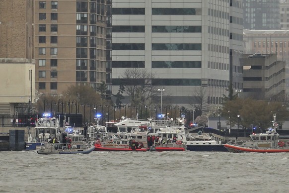 As seen from Pier 40 in New York, police and fire crews from New York and New Jersey respond to the scene Thursday, April 10, 2025, where a helicopter went down in the Hudson River between Manhattan a ...