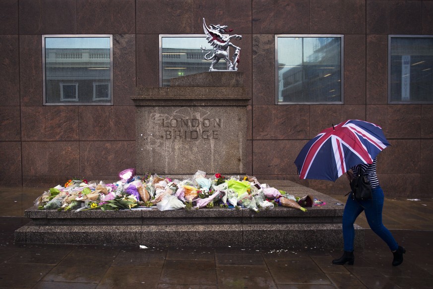 epaselect epa06012898 A member of the public passes flowers and tributes left for victims of the London Bridge terror attacks, on London Bridge in Central London, Britain, 06 June 2017. Seven people h ...