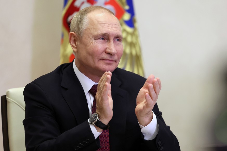 Russian President Vladimir Putin claps as he takes part in the ceremony to raise the Russian national flag on the nuclear-powered Ural icebreaker and launch Russia's newest and largest nuclear power plant.