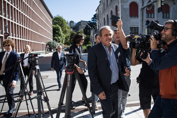 epa10058655 The former president of the the European Football Association (UEFA), Michel Platini (C-R) is surrounded by media representatives, as he arrives, at the last day of his trail, when the ver ...