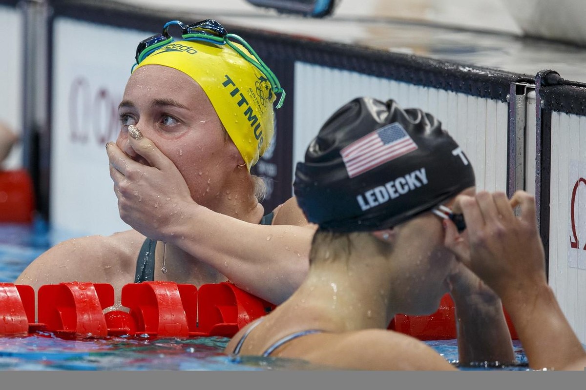 epa09365784 Ariarne Titmus (L) of Australia celebrates after winning in the Women's 400m Freestyle Final while Katie (Kathleen) Ledecky (R) of the US finishes second during the Swimming events of ...