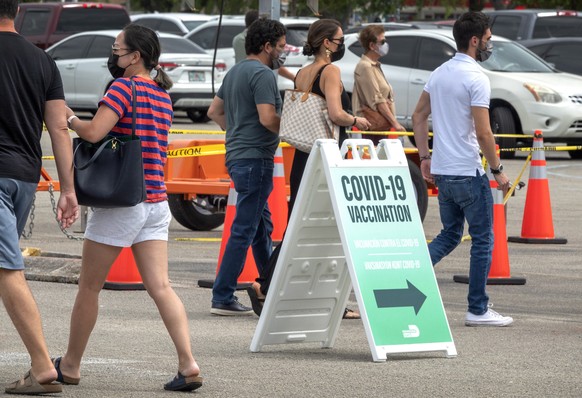 epa09107055 People queue in a line to get the COVID-19 Vaccine at the FEMA Vaccination site opened in Miami-Dade College in Miami, Florida, USA, 30 March 2021. With state partners, the Federal Emergen ...