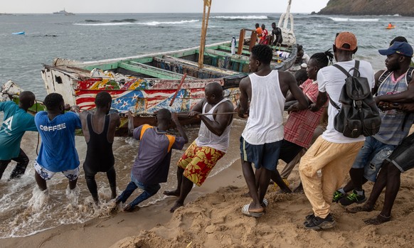 epaselect epa10766301 Rescuers and fishermen work to free a beached pirogue stuck on the sand in Ouakam, Dakar, Senegal, 24 July 2023. At least 15 people have died after this pirogue capsized in the m ...