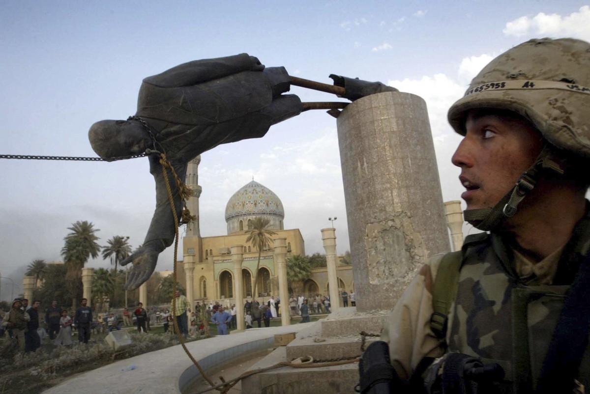 U.S. Marine Corp Assaultman Kirk Dalrymple watches as a statue of Iraq's President Saddam Hussein falls in central Baghdad's Firdaus Square in this April 9, 2003 file photo. To match Special ...