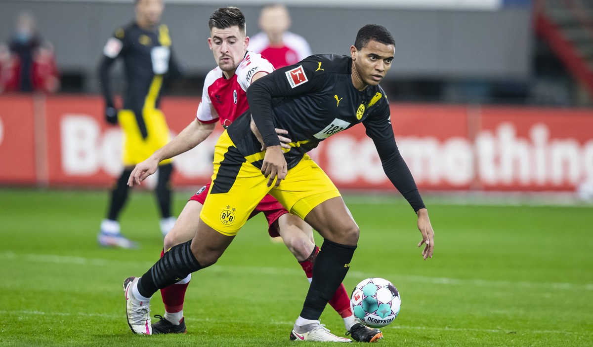 Freiburg's Baptiste Santamaria, left, and Dortmund's Manuel Akanji challenge for the ball during the German Bundesliga soccer match between SC Freiburg and Borussia Dortmund in Freiburg, Ger ...