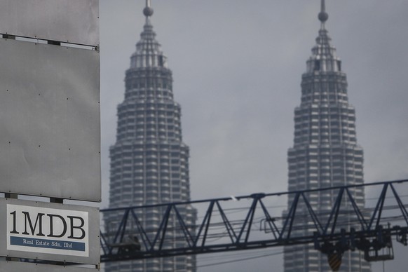 FILE - In this Wednesday, July 8, 2015 photo, a 1MDB (1 Malaysia Development Berhad) logo is set against the Petronas Twin Towers at the flagship development site, Tun Razak Exchange in Kuala Lumpur,  ...