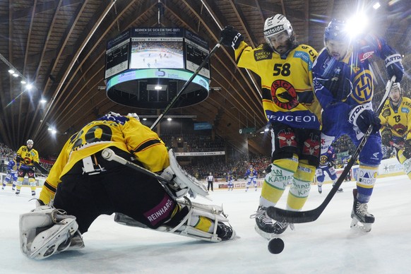 Devin Setoguchi von Davos, rechts, trifft zum 3-1 gegen Torhueter Jakub Stepanek und Eric Blum von Bern, von links, beim dritten Playoff-Halbfinalspiel der National League A zwischen dem HC Davos und  ...