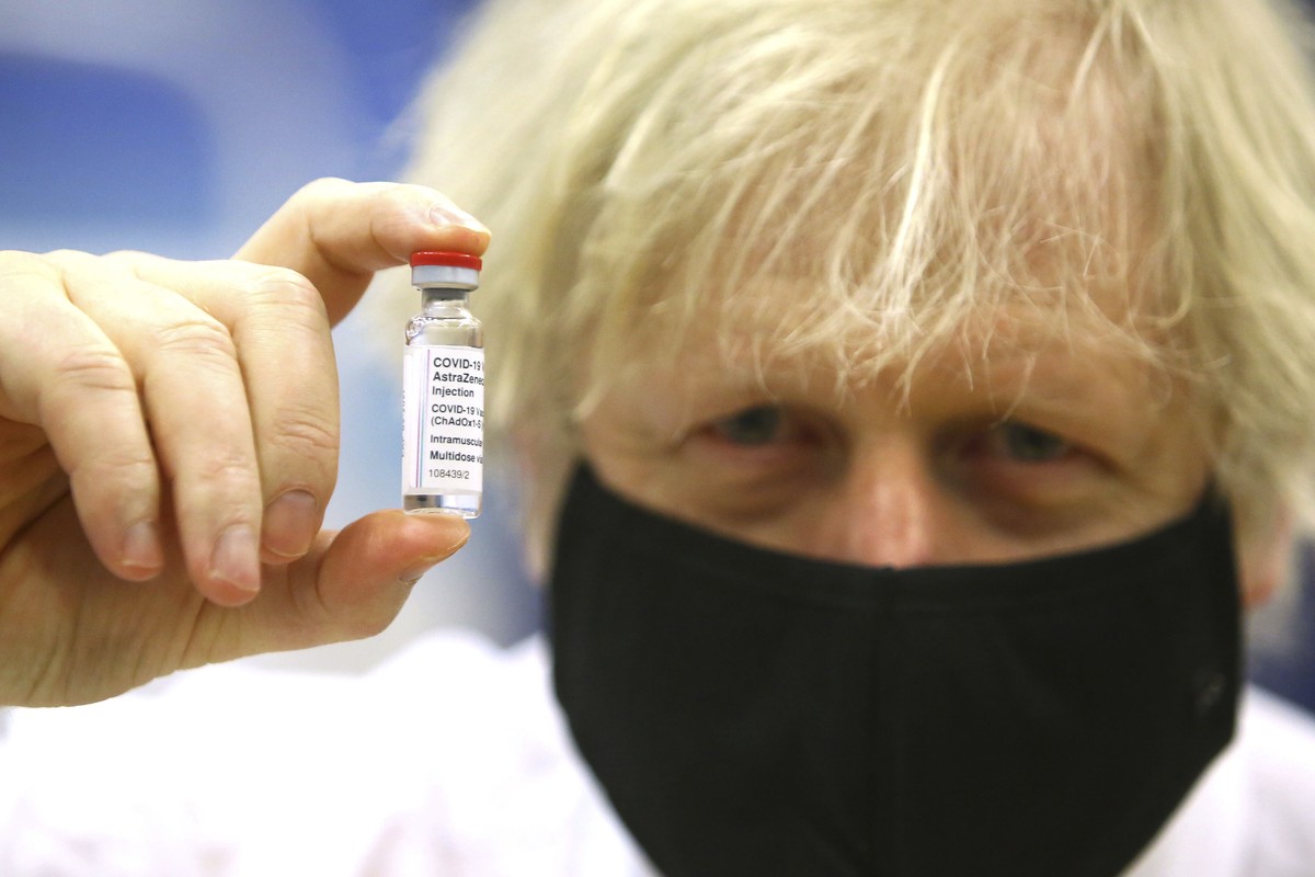 Britain's Prime Minister Boris Johnson holds a vial of the Oxford/Astra Zeneca Covid-19 vaccine at a vaccination centre in Cwmbran, south Wales, Wednesday Feb. 17, 2021. (Geoff Caddick/Pool via A ...