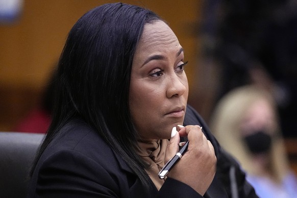 FILE - Fulton County District Attorney Fani Willis watches proceedings during a hearing to decide if the final report by a special grand jury looking into possible interference in the 2020 presidentia ...