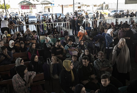 epaselect epa10952651 Palestinians wait to cross into Egypt at the Rafah border crossing between the Gaza Strip and Egypt, in Gaza, 01 November 2023. Ambulances carrying evacuees from the Gaza Strip w ...