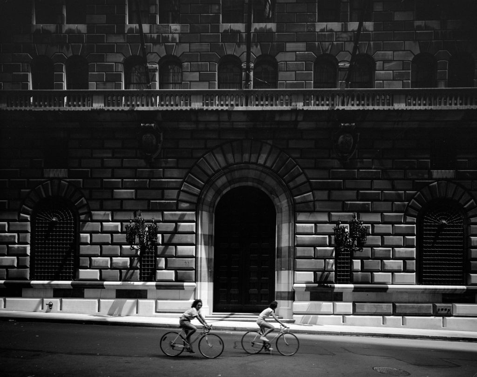 View of two cyclists riding past the Federal Reserve Bank of New York at 33 Liberty Street, New York, New York, circa 1979. (Photo by Edmund Vincent Gillon/Museum of the City of New York/Getty Images)