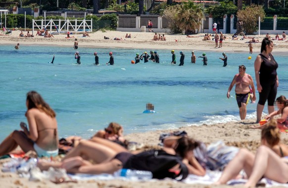 epa08410608 People take advantage of the beautiful day sunbathing and swimming in the sea on the beach of Mondello, a long sandy coast, in Palermo, Italy, May 08, 2020. The Italian government is gradually ...