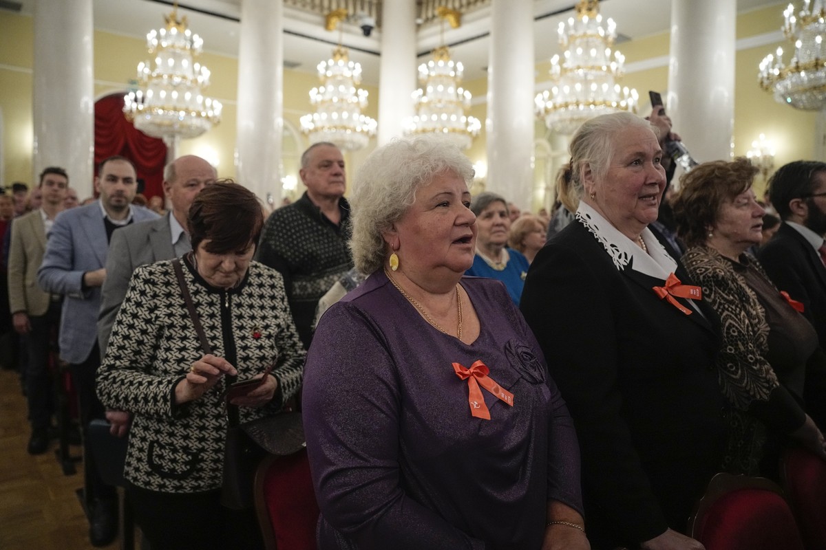 Russian Communist Party members and supporters listen to the Soviet anthem as they gather at Pillar Hall of the House of the Unions to mark the 100th anniversary of the USSR's establishment, in M ...