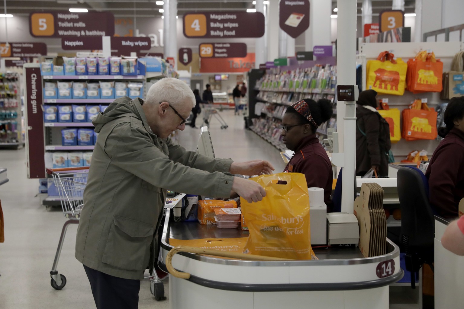 A customer buys shopping at a till in the Sainsbury&#039;s flagship store in the Nine Elms area of London, Monday, April 30, 2018. Sainsbury&#039;s has agreed to buy Walmart&#039;s U.K. unit, Asda, fo ...