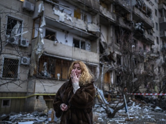 Natali Sevriukova reacts next to her house following a rocket attack the city of Kyiv, Ukraine, Friday, Feb. 25, 2022. (AP Photo/Emilio Morenatti)
