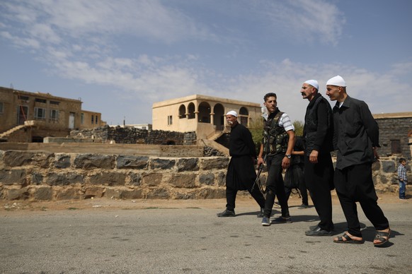 FILE - Druze men walk in the village of Rami in the southern province of Sweida, Syria, Thursday, Oct. 4, 2018. (AP Photo/Hassan Ammar, File)