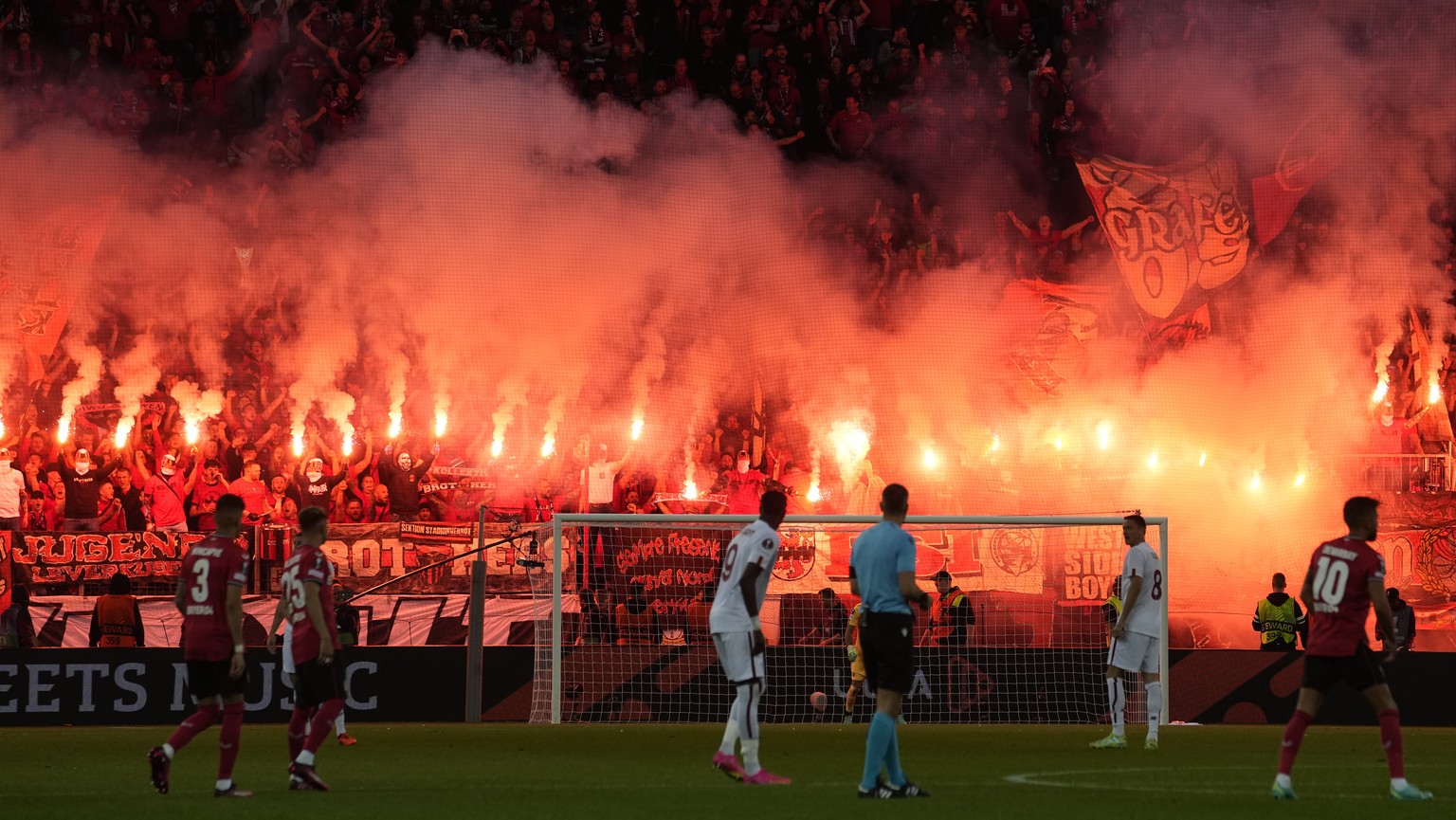 Leverkusen supporters light flares during the Europa League semifinal second leg soccer match between Bayer Leverkusen and Roma at the BayArena in Leverkusen, Germany, Thursday, May 18, 2023.(AP Photo ...