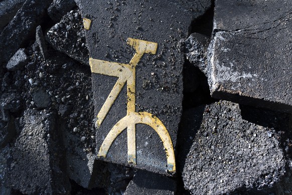 Ein Velosymbol zwischen aufgebrochenem Teer, fotografiert auf einer Baustelle beim Tierpark Lange Erlen in Basel am Montag, 15. Mai 2017. Die Stimmbuergerinnen und Stimmbuerger des Kantons Basel-Stadt ...