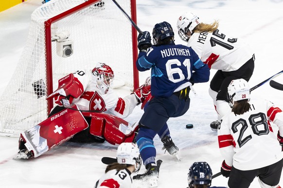 epa12741169 Switzerland's goaltender Andrea Braendli (L), Finland's Emma Nuutinen (C), and Switzerland's Laure Meriguet (R) during the Women's quarter final match Finland against S ...