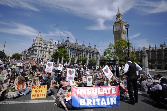 Members of environmental groups including Just Stop Oil, the Peace and Justice Project and Insulate Britain take part in a mass protest, in Parliament Square in London, Saturday, July 23, 2022. (AP Ph ...