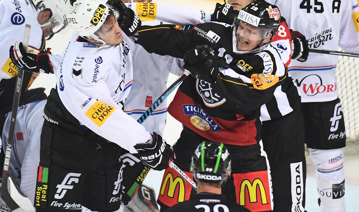 Lugano’s player Patrik Zackrisson, right, fights with Fribourg's player Christopher Rivera, left, during the preliminary round game of National League A (NLA) Swiss Championship 2016/17 between H ...