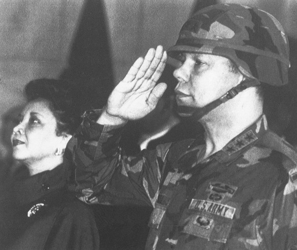 FILE - In this Dec. 30, 1986, file photo, U.S. Lieutenant General Colin Powell, commander of the 5th U.S. corps, salutes while his wife Alma stands in attention during a farewell ceremony in Frankfurt ...