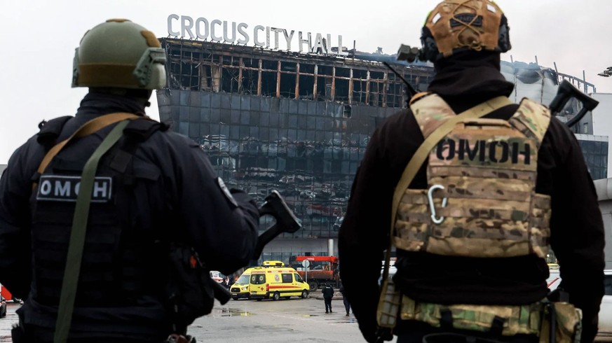 Polizisten vor der abgebrannten Crocus City Hall: Bilder und Videos zeigen, wie russische Sicherheitskräfte die mutmaßlichen Terroristen foltern sollen. (Quelle: IMAGO/Vyacheslav Prokofyev/imago)