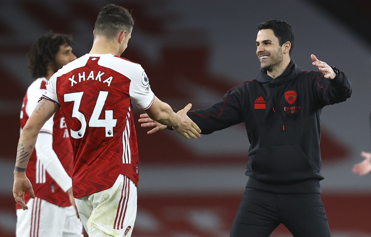 Arsenal's manager Mikel Arteta greets Arsenal's Granit Xhaka at the end of during the English Premier League soccer match between Arsenal and Tottenham Hotspur at the Emirates stadium in Lon ...