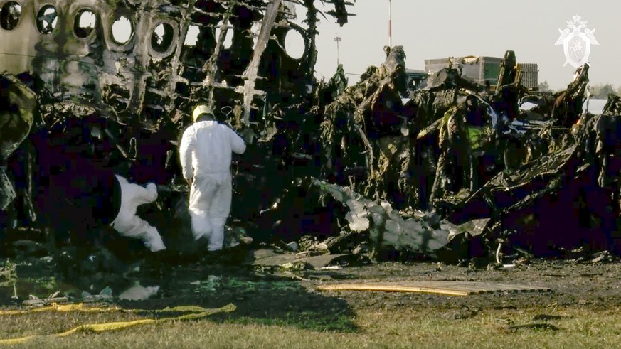 This photo taken from a video distributed by Russian Investigative Committee on Monday, May 6, 2019, shows employees of the Russian Investigative Committee working at the wreckage of the Sukhoi SSJ100 ...