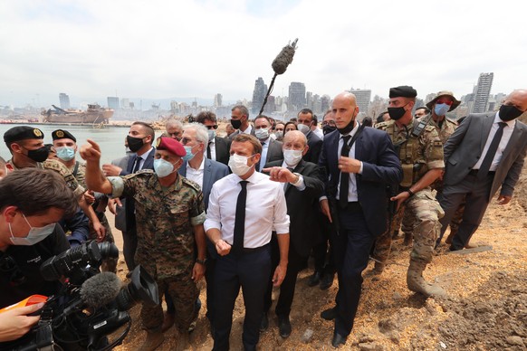 epa08587498 A handout photo made available by the Lebanese government official photographer Dalati and Nohra showing French President Emmanuel Macron (C) visiting the devastated site of the explosion at the port of Beirut, Lebanon, 06 August 2020. Macron arrived to Lebanon to show support after a massive explosion on 04 August in which at least 137 people were killed, and more than 5,000 injured in what believed to have been caused by an estimated 2,750 of ammonium nitrate stored in a warehouse.  EPA/DALATI NOHRA HANDOUT  HANDOUT EDITORIAL USE ONLY/NO SALES