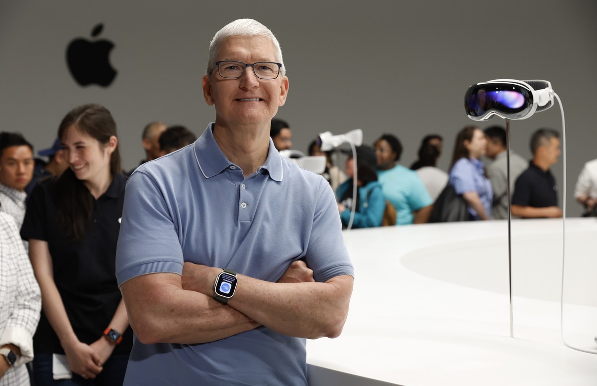 epa10675119 Apple CEO Tim Cook (R) reacts as developers and members of the media photograph and examine products following the keynote address for the 2023 Apple Worldwide Developers Conference (WWDC) ...