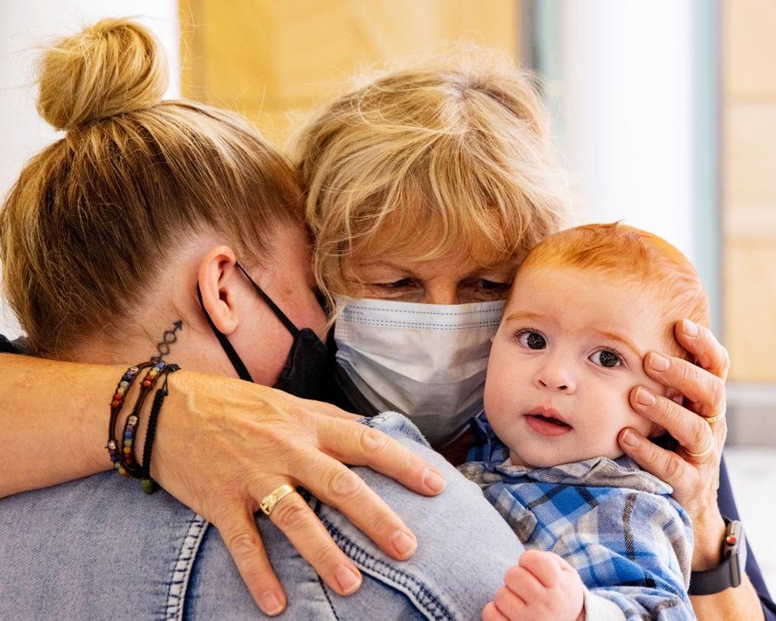 SYDNEY, AUSTRALIA - APRIL 19: Dianne Wright (C) hugs daughter Tania Wright and baby Mason Buckley at Sydney International Airport on April 19, 2021 in Sydney, Australia. The trans-Tasman travel bubble ...