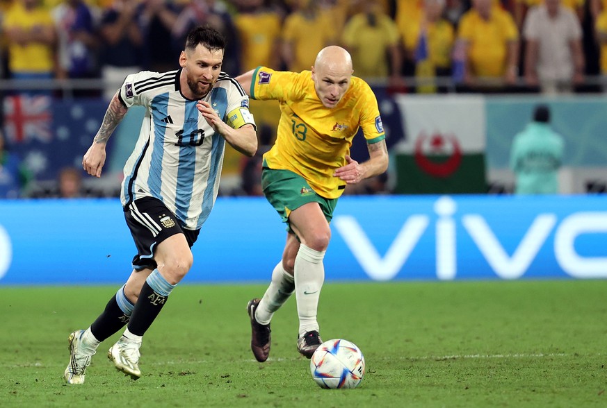 epa10346962 Lionel Messi (L) of Argentina in action against Aaron Mooy of Australia during the FIFA World Cup 2022 round of 16 soccer match between Argentina and Australia at Ahmad bin Ali Stadium in  ...