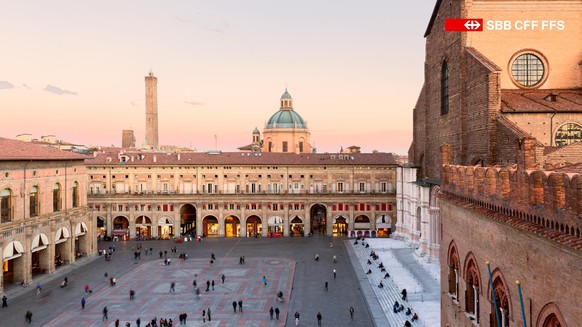 Die Piazza Maggiore Bolognas bei Sonnenuntergang, wo sich historische Architektur mit dem lebendigen Puls der Stadt vereint.