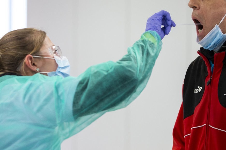 Eine Mitarbeiterin des Testcenters macht einen Abstrich bei einem Mann, beim mobilen Coronavirus Testcenter im BEA Gelaende, am Montag, 30. Maerz 2020 in Bern. Das Testcenter steht seit Montagnachmitt ...