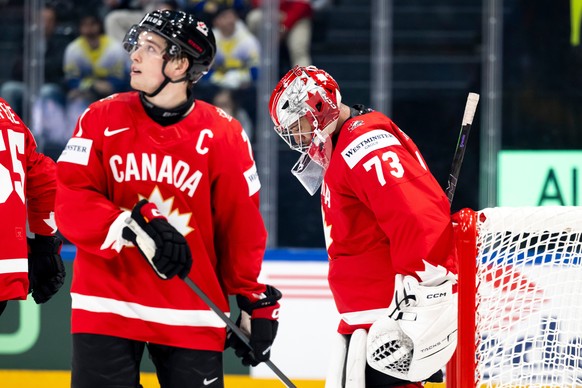 Canada's Macklin Celebrini, left, and goaltender Jet Greaves, right, react during a Group B preliminary round game between Canada and Sweden at the men's ice hockey world championship in Fri ...