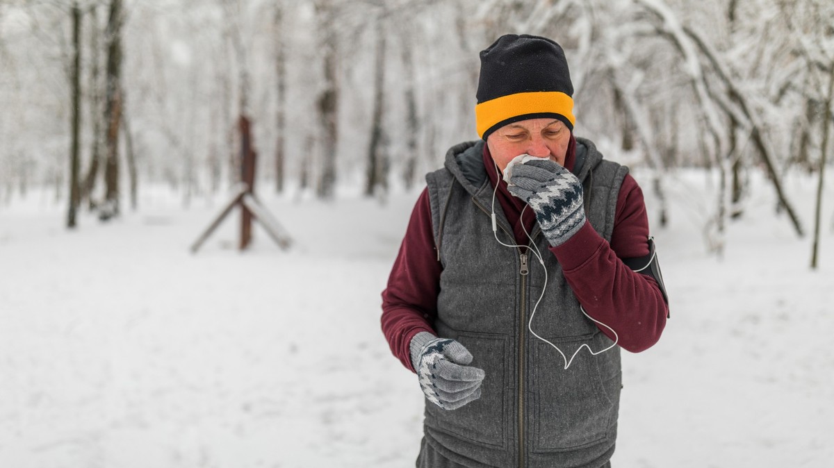 Senior man jogging in snow