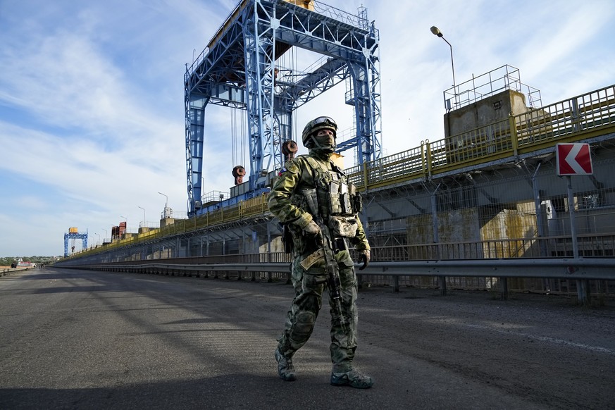 FILE - A Russian soldier patrols an area at the Kakhovka Hydroelectric Station, a run-of-river power plant on the Dnieper River in Kherson region, south Ukraine, on May 20, 2022. Even as the Russian w ...