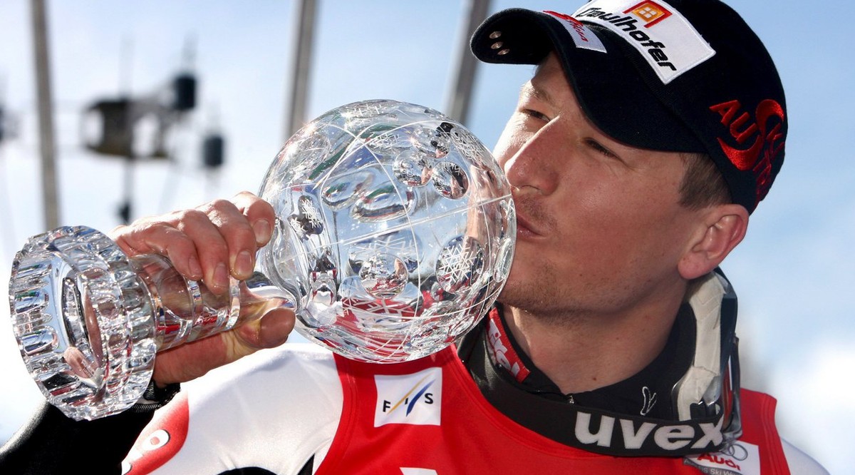 epa01283381 Austria's Hannes Reichelt kisses the crystal globe trophy after winning the men's Super-G World Cup on the podium of the Alpine Skiing World Cup Finals in Bormio, northern Italy, ...