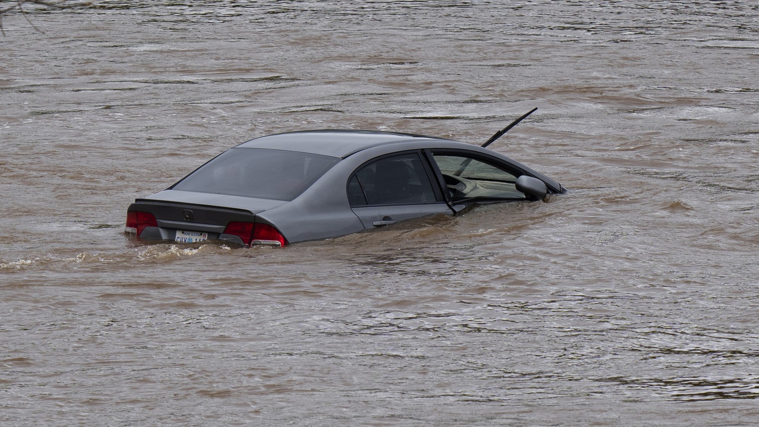 An abandoned car in a mall parking lot sits in floodwaters following a major rain event in Halifax, Nova Scotia, Canada, on Saturday, July 22, 2023. (Darren Calabrese/The Canadian Press via AP)