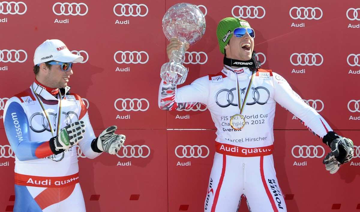 Austrian Marcel Hirscher right, celebrates in the finish area holding the crystal globe of the winner of the Overall standing next to Switzerland's Beat Feuz, left, 2n place of the overall standi ...