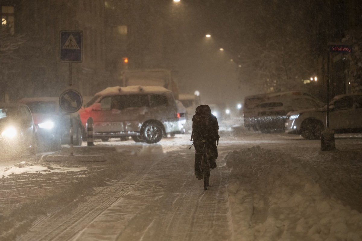 Autos stauen sich bei starkem Schneefall waehrend Velofahrerinnen versuchen in der Spur zu bleben, am Donnerstag, 21. November 2024 im Lorrainequartier in Bern. Der Schneesturm brachte den Ferabendver ...