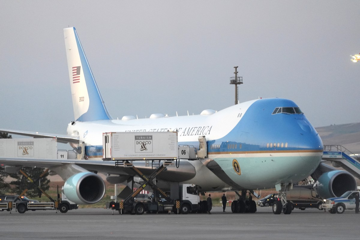 Catering trucks are parked at Air Force One on the tarmac as the motorcade carrying U.S. President Donald Trump arrives on the tarmac to depart following the NATO summit at Ankara International Airpor ...