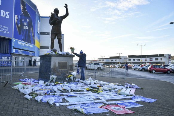 Flowers and tributes are placed near the statue of Cardiff City footballer Frederick Charles Keenor outside Cardiff City Football Club, Wales, Wednesday Jan. 23, 2019, after a plane with new signing E ...