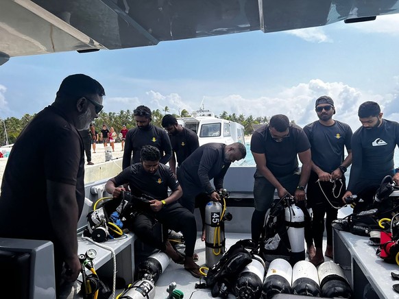 epa12967657 A handout photo made available by the Maldives President's Media Division shows Maldives National Defence Force (MNDF) military diver Staff Sergeant Mohammed Mahdi (2-L) and other div ...