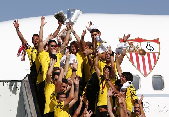 Sevilla's team celebrates with the Europa League trophy after landing in the Andalusian capital of Seville, May 15, 2014. Sevilla are looking to build on their thrilling Europa League success after overcoming Benfica in a penalty shootout in Wednesday's nerve-shredding final in Turin. REUTERS/Marcelo del Pozo (SPAIN - Tags: SPORT SOCCER)